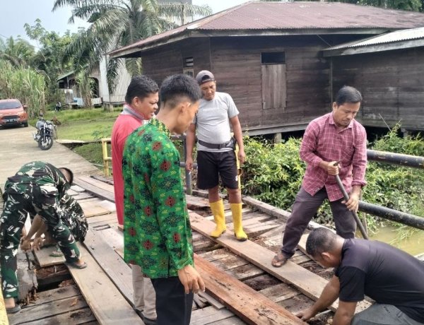 Perkuat Kemanunggalan TNI dan Rakyat, Satgas TMMD ke-129 Kodim 0313/KPR dan Warga Gotong Royong Perbaiki Jembatan jalan Desa