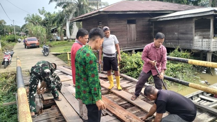 Perkuat Kemanunggalan TNI dan Rakyat, Satgas TMMD ke-129 Kodim 0313/KPR dan Warga Gotong Royong Perbaiki Jembatan jalan Desa